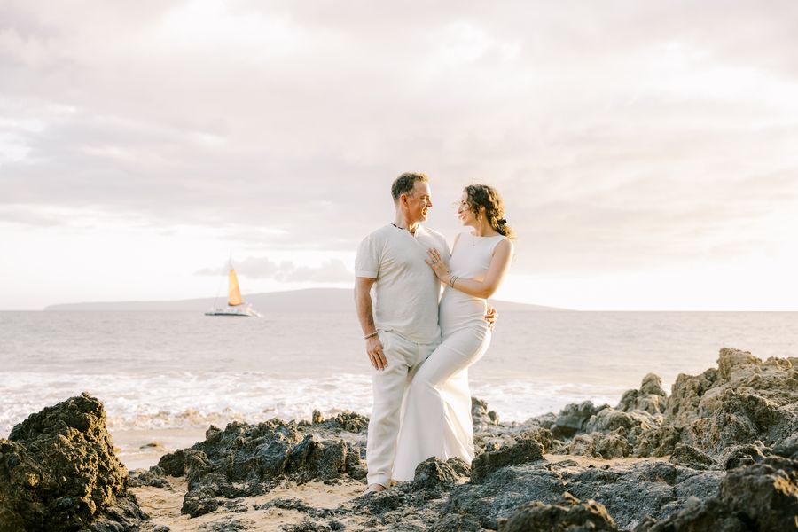 Pete and Danielle standing together on lava rocks at a Maui beach