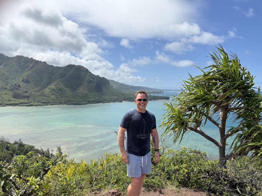 Pete above a turquoise bay on the Crouching Lion hike in Hawaii